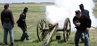 Soldiers firing the mountain howitzer.